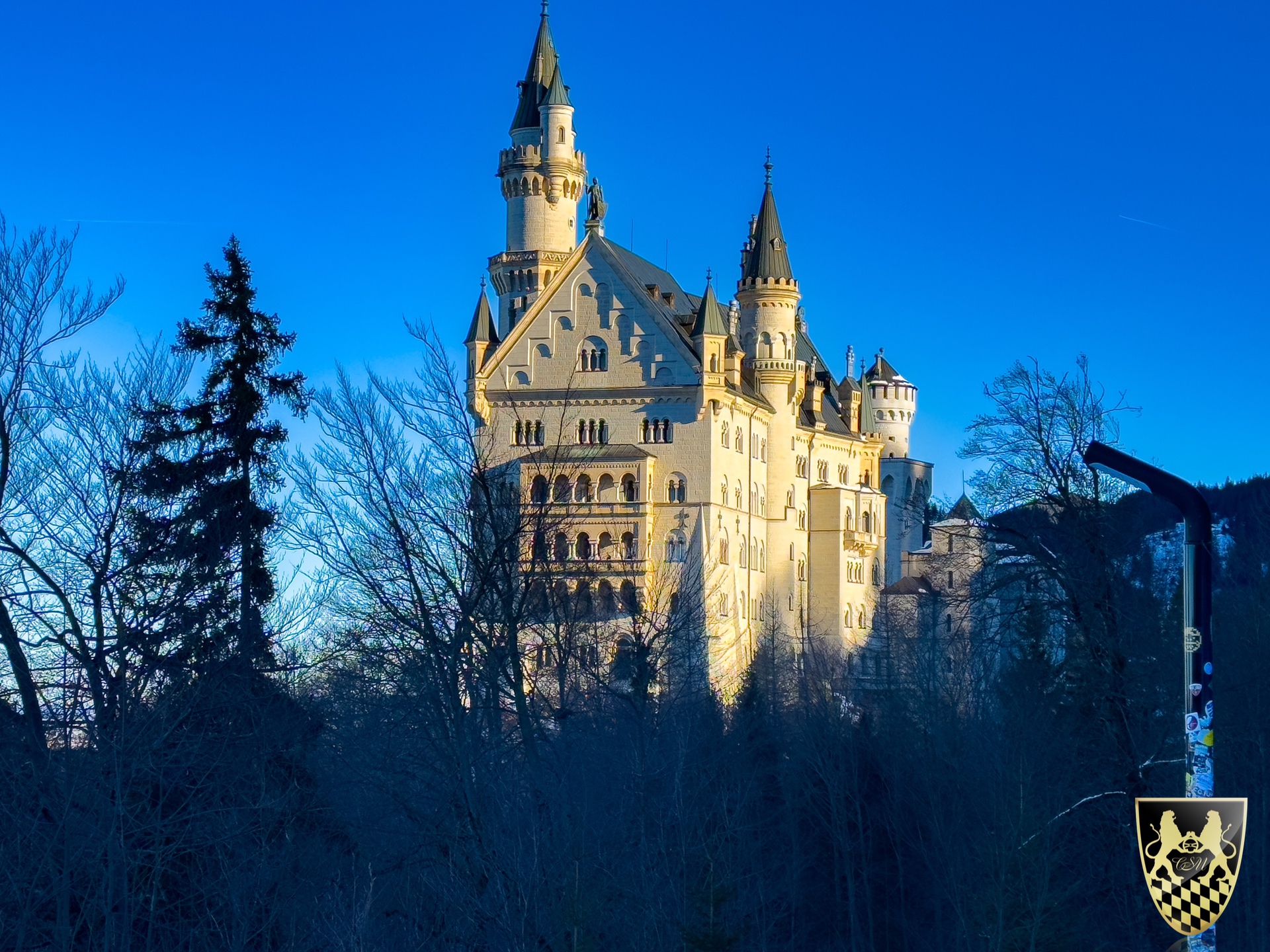 Castle with tall spires against a clear blue sky at sunset.